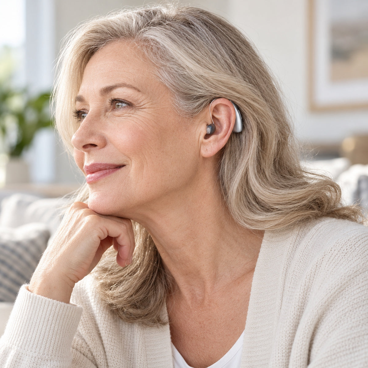 Older woman wearing a silver Mearsun CZ-B811 behind-the-ear hearing aid at home